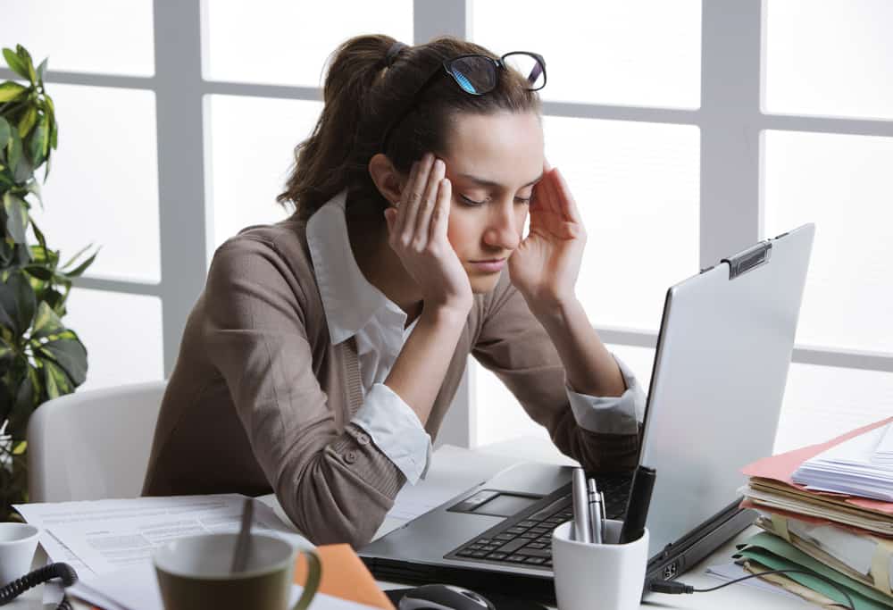women with headache at computer