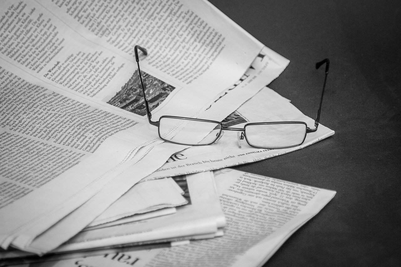 newspaper and a pair of glasses