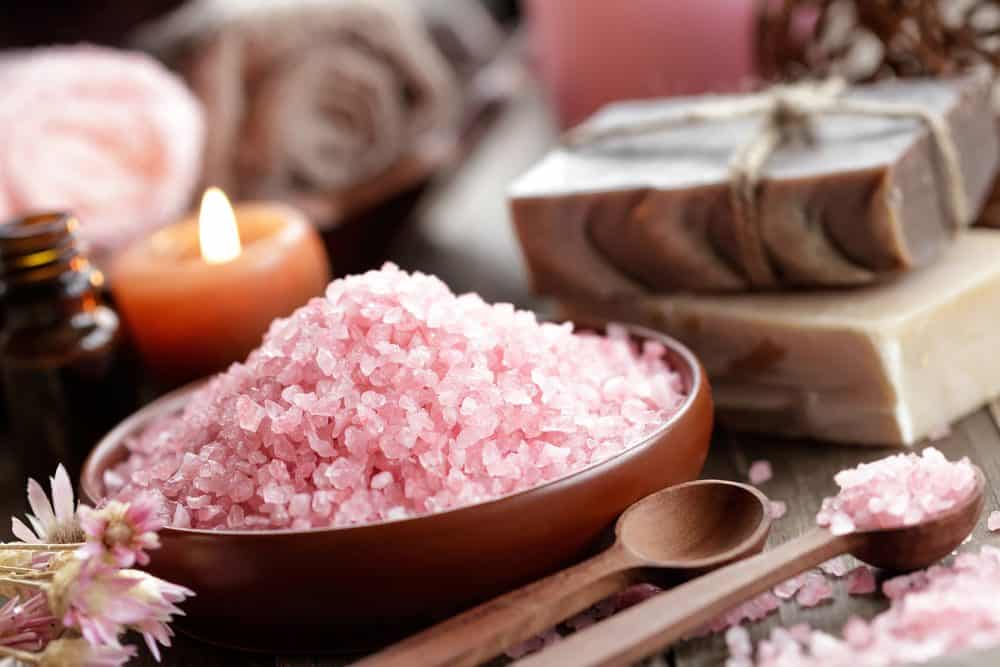 himalayan salt in a bowl with spoons and candles