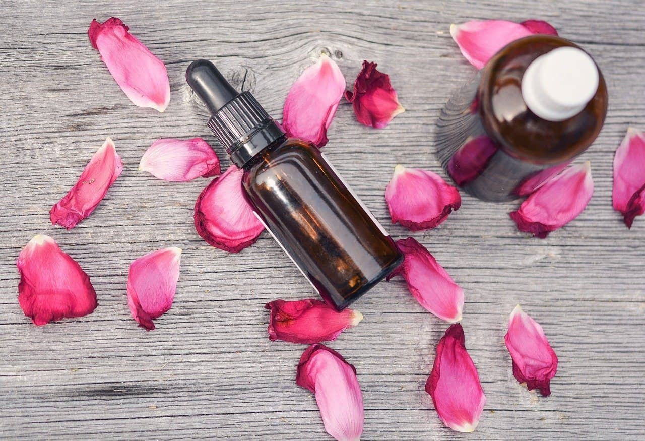 bottles of essential oils and flower petals