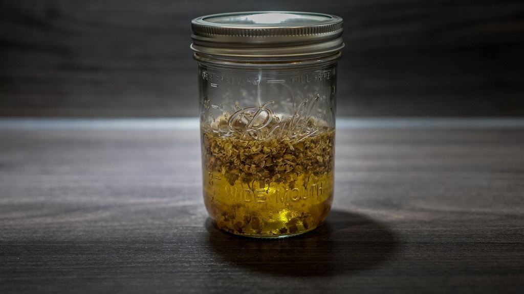 chamomile flowers and carrier oil in a mason jar