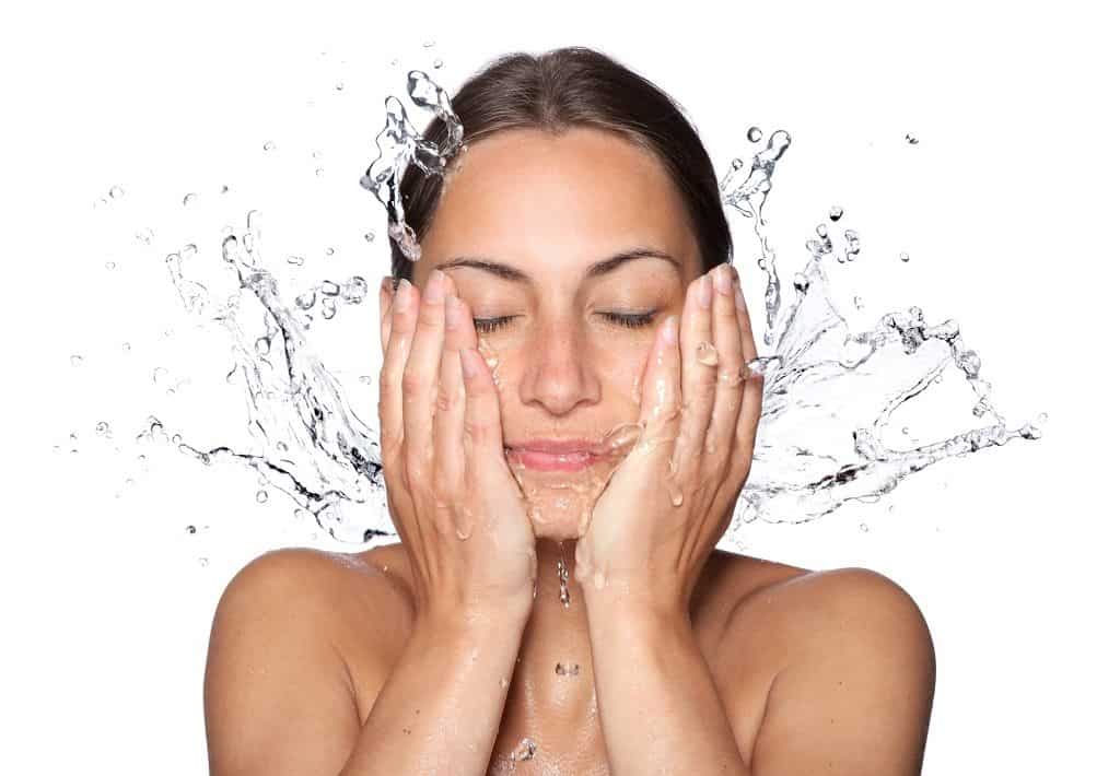 woman washing her face to prepare for the aloe vera face mask